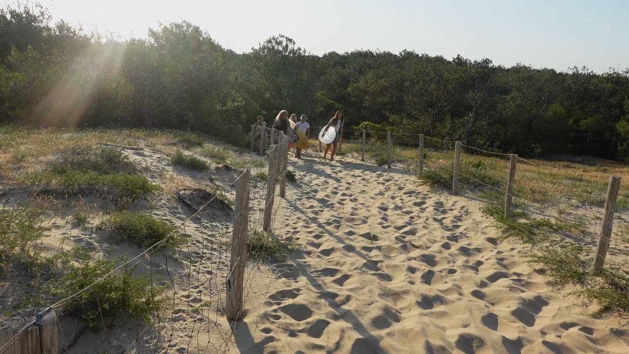 Traversée des dunes vers la plage de Cap Océan avec les planches de surf