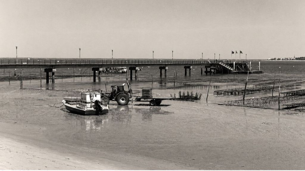 Bélisaire au Cap Ferret avec l’embarcadère, les parcs à huîtres, un chaland et un tracteur ostréicole